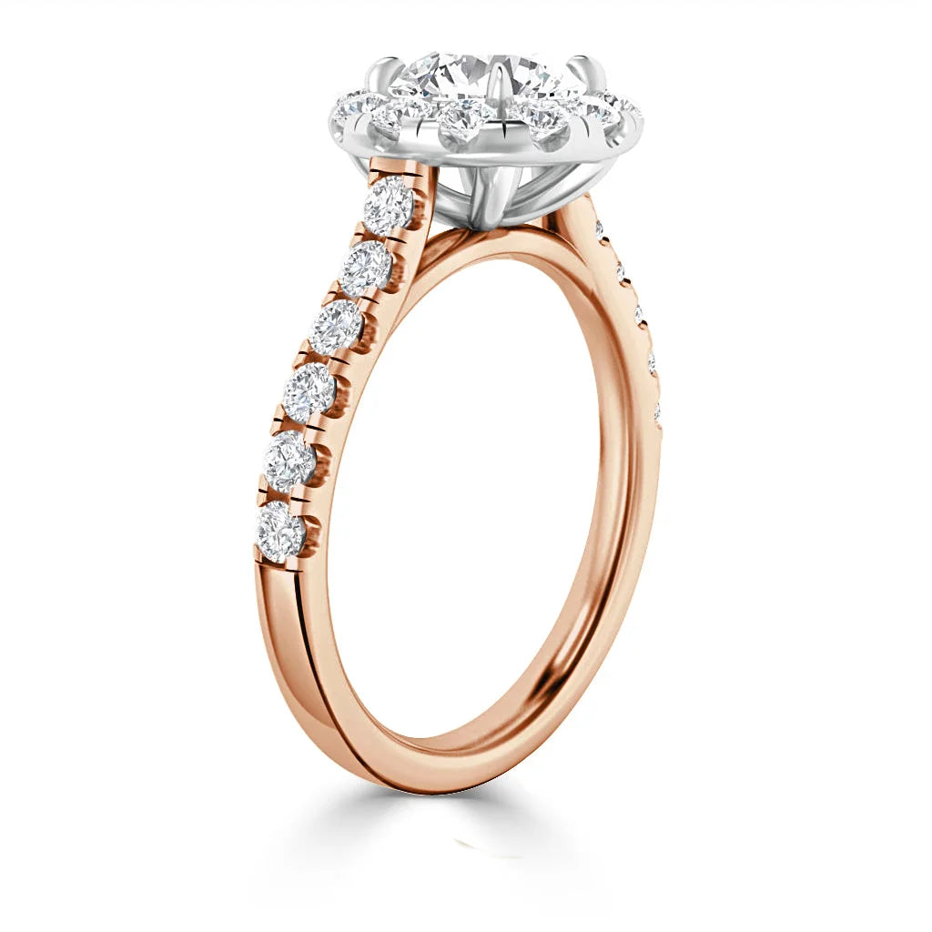 Rose gold ring with round diamond halo setting and diamonds along the band, viewed from the side.