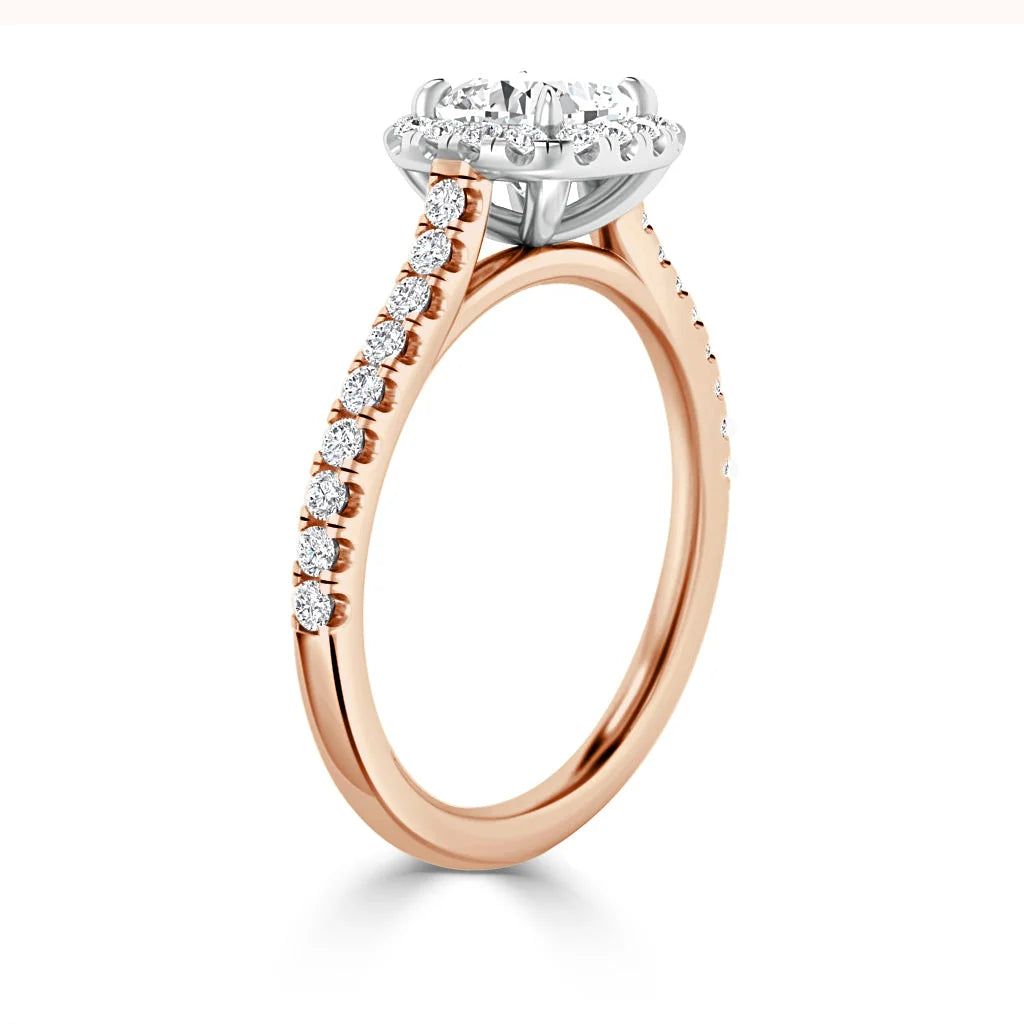Rose gold ring with diamond accents on band and a large round center diamond in a white gold setting.