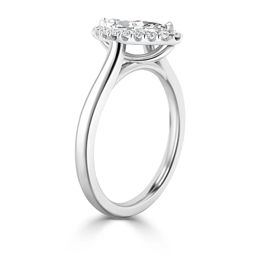 A white gold ring with a round center diamond and a diamond halo setting, viewed from the side.