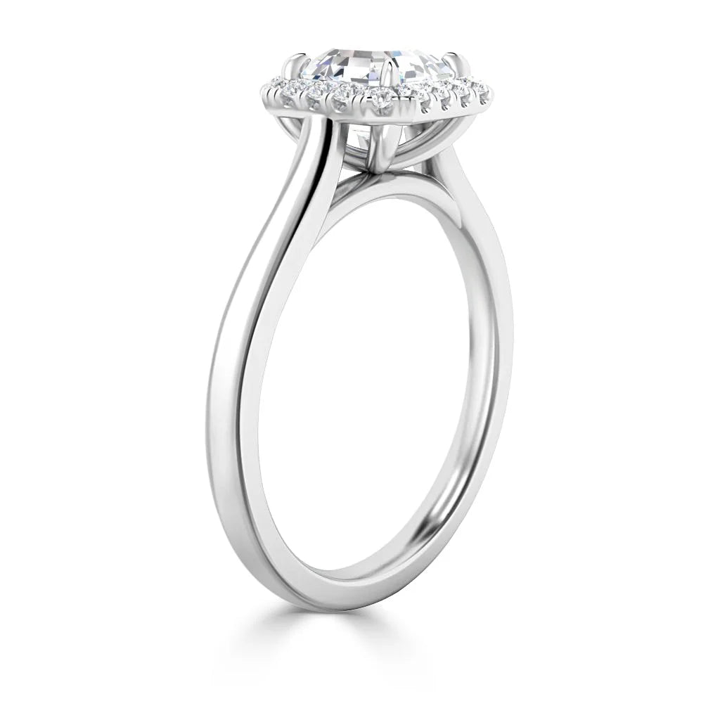 Side view of a silver ring with a round halo setting and a raised central diamond surrounded by smaller diamonds.