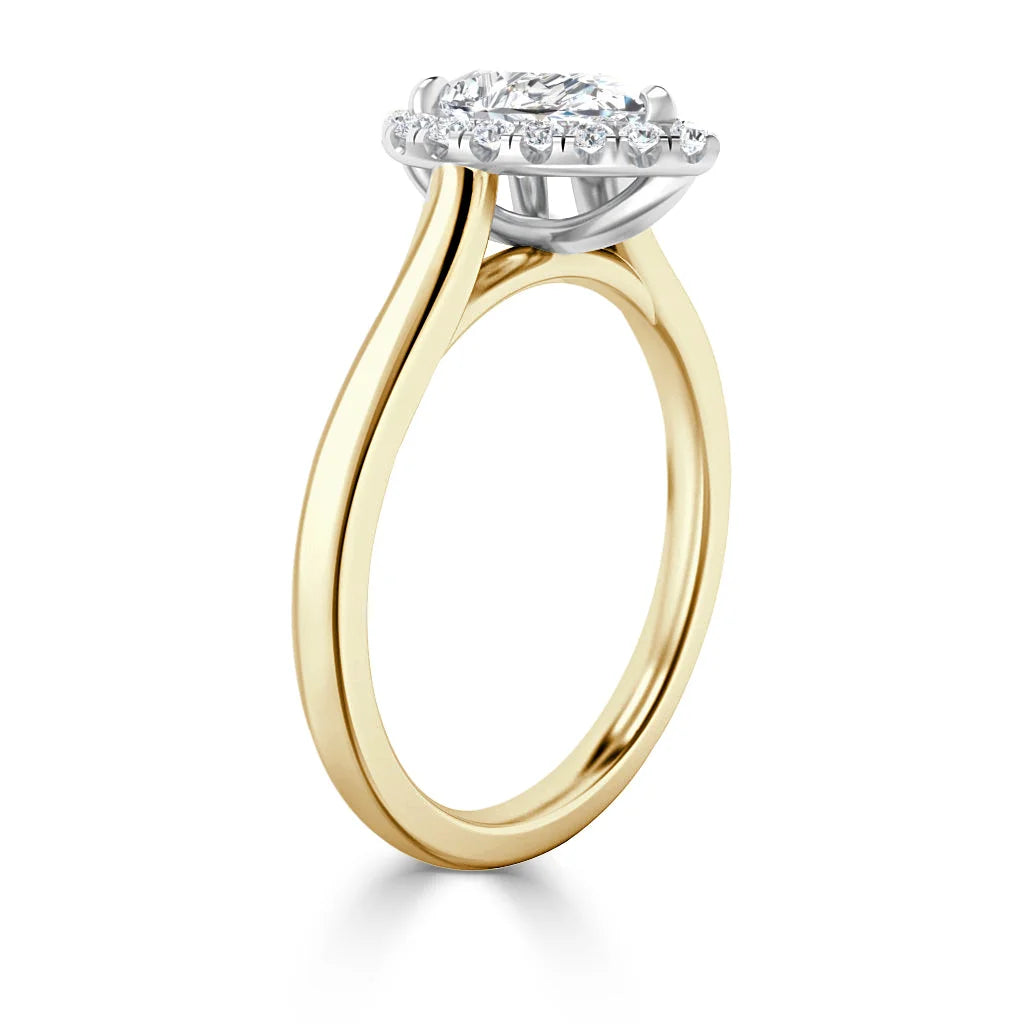 Gold ring with a round diamond halo setting, viewed from the side to show the thin band and elevated setting.