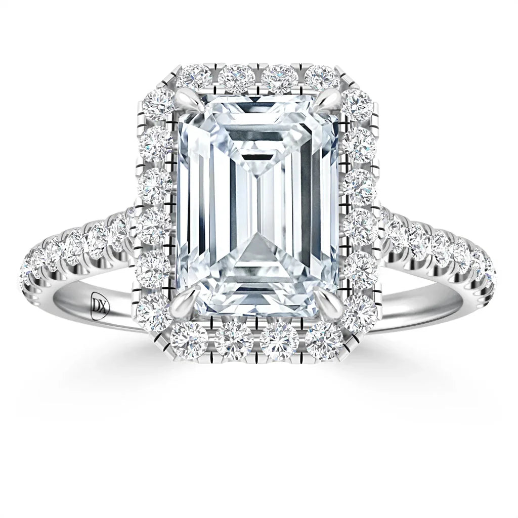 Emerald-cut diamond ring with a halo of small diamonds and a diamond-encrusted band on white background.