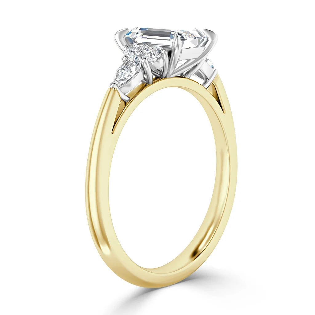 A gold ring with a large rectangular diamond and two smaller side diamonds in a white metal setting.