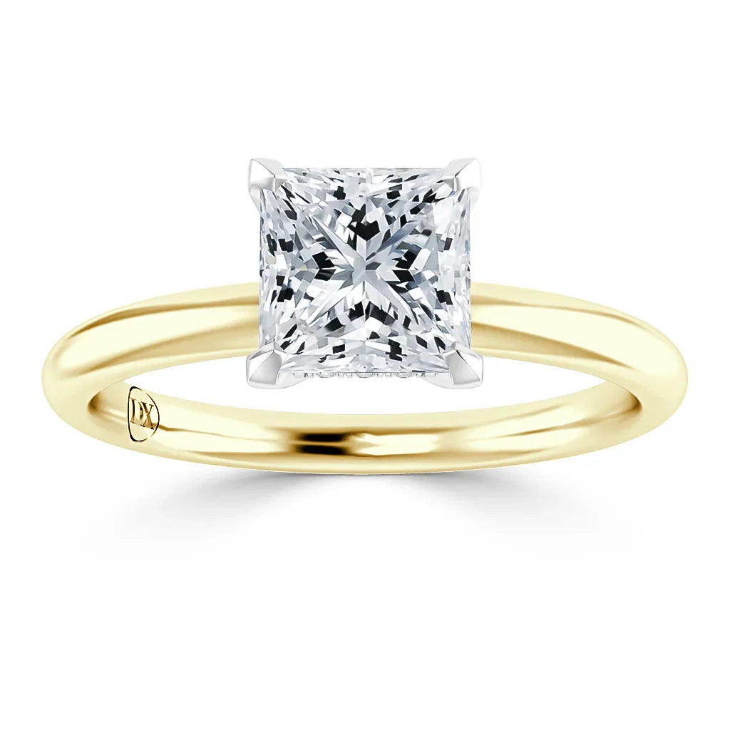 A gold ring with a large, square-cut diamond solitaire set in a four-prong white gold setting.