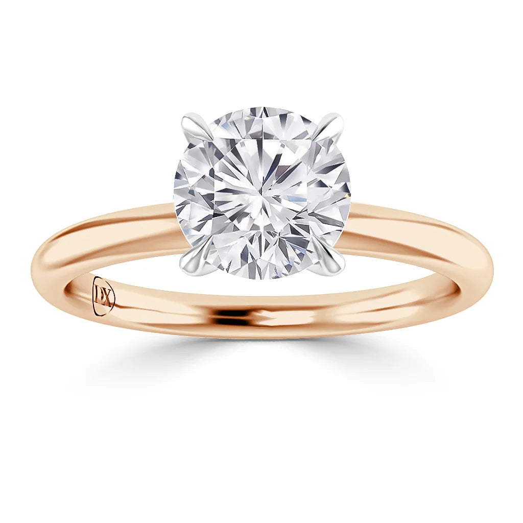 A round diamond solitaire ring with a rose gold band and white gold prongs, viewed from the front.