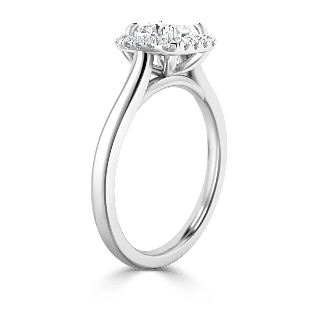 A white gold ring with a round halo setting and a center diamond, shown from a side angle.