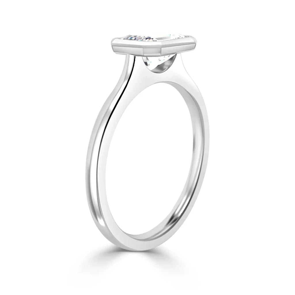 A slim silver ring with a single oval gemstone set horizontally in a minimalist, modern bezel setting.