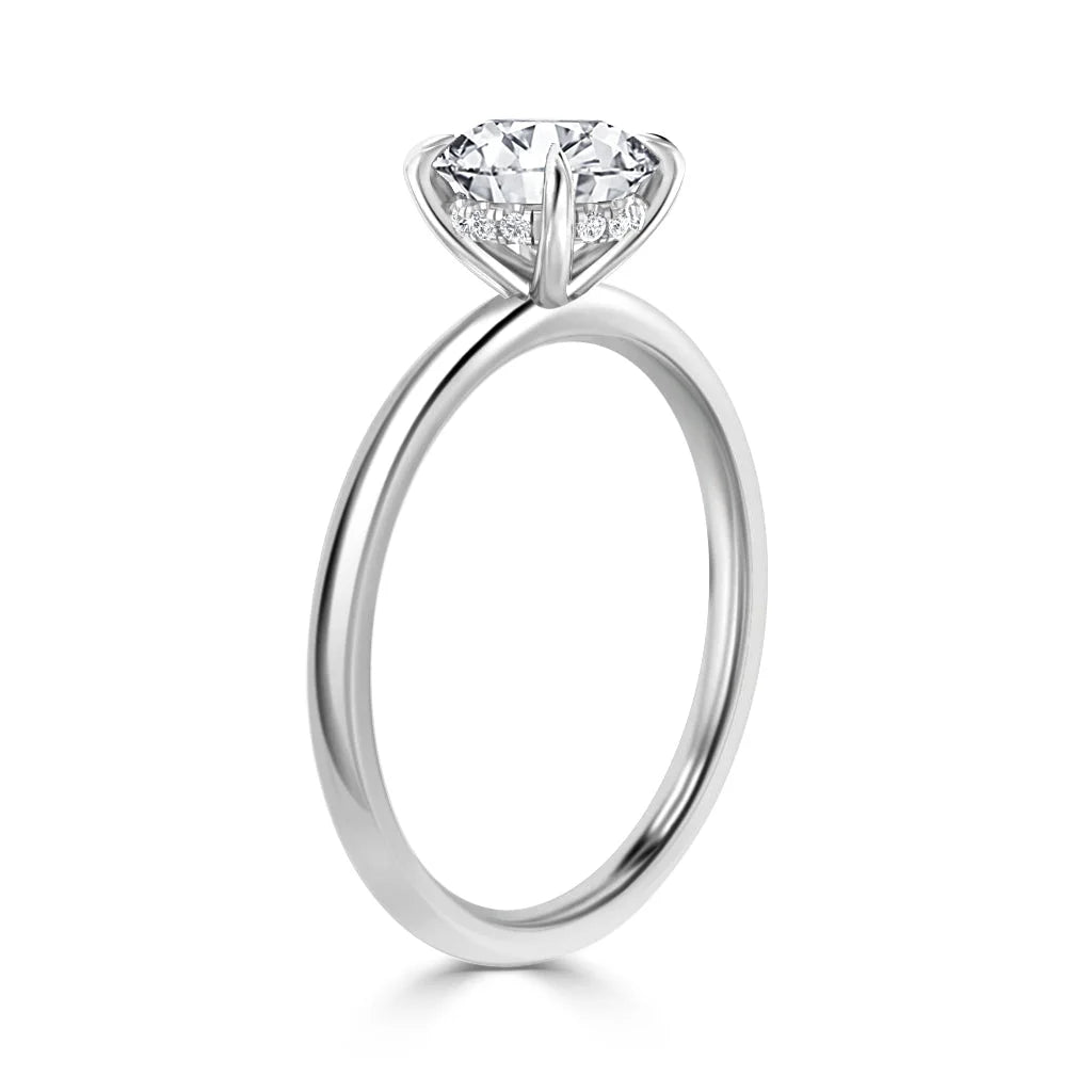 A solitaire diamond ring with a thin silver band and a round, prong-set diamond in a simple setting.