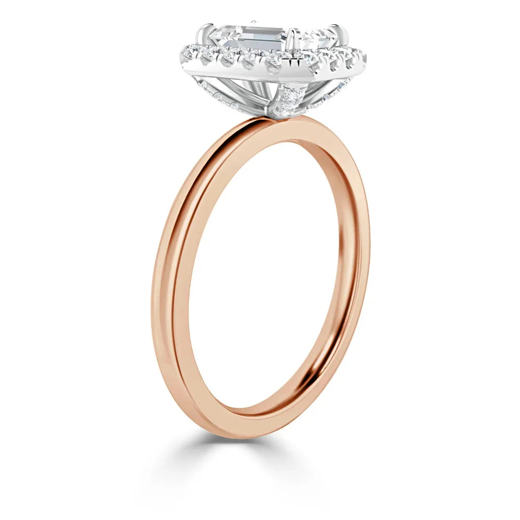 A rose gold ring with a large emerald-cut diamond and a halo of smaller diamonds in a white gold setting.