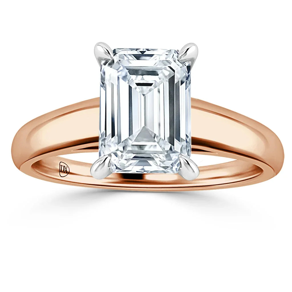 Emerald-cut diamond solitaire ring with a rose gold band and four prongs holding the stone.