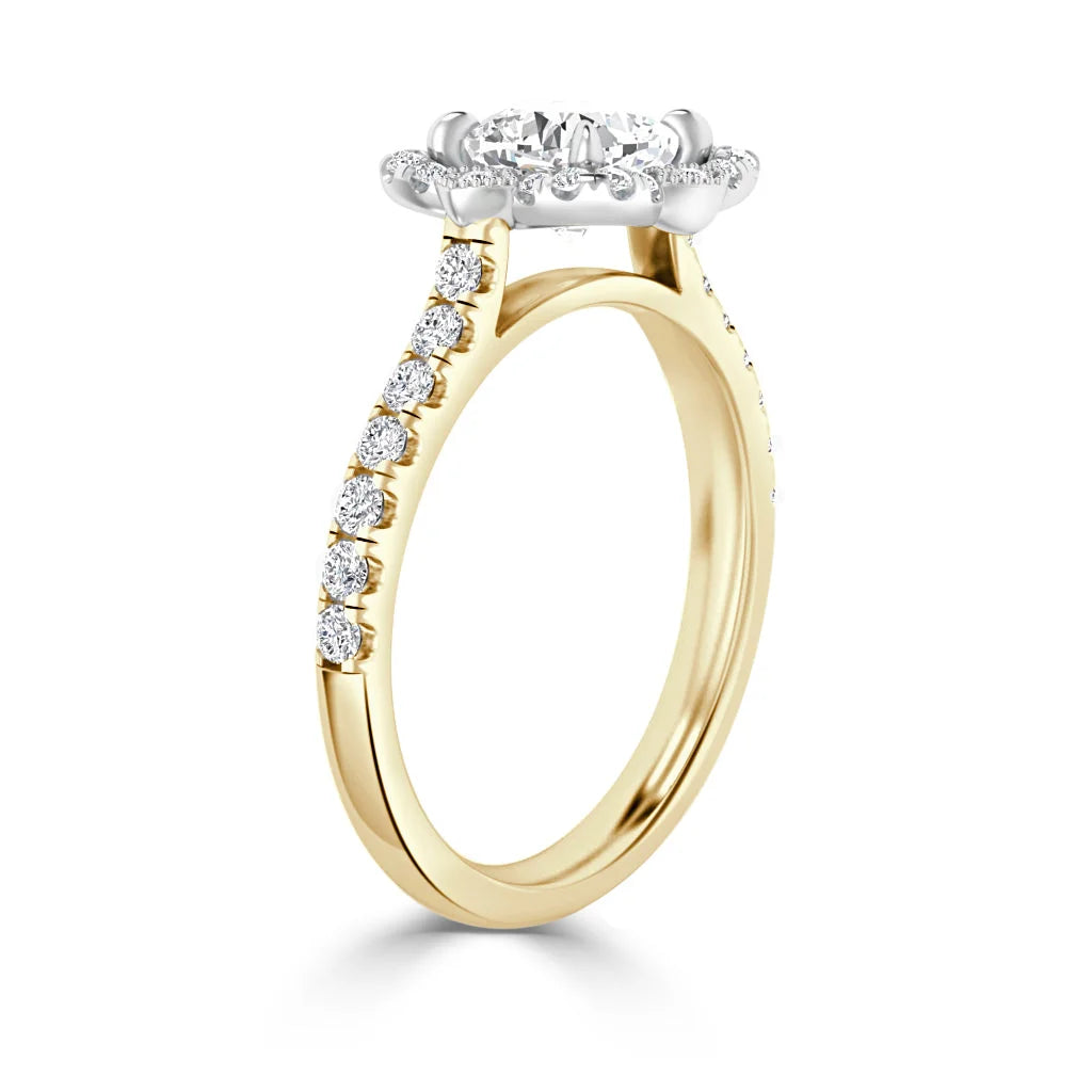 Gold ring with a diamond halo setting and diamonds along the top half of the band, viewed from an angle.