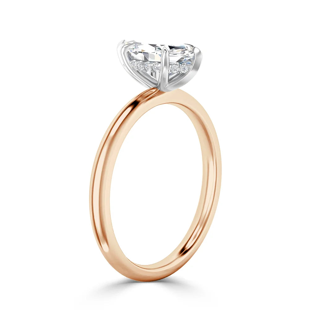 A rose gold ring with a round solitaire diamond set in a white gold prong setting, shown on a white background.