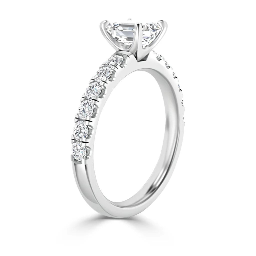 White gold engagement ring with a round center diamond and small diamonds set along the band.
