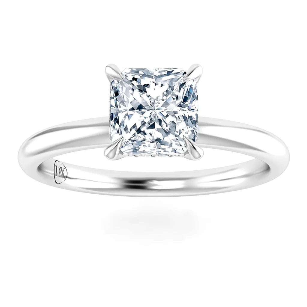 A solitaire ring with a princess-cut diamond on a simple, polished white metal band.