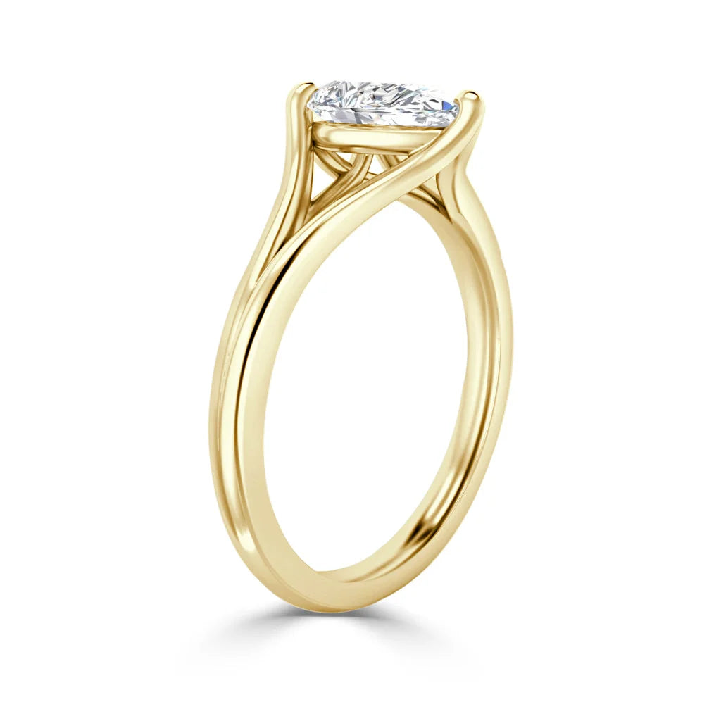 A gold solitaire ring with a round, prong-set diamond and an elegant, twisted band design.