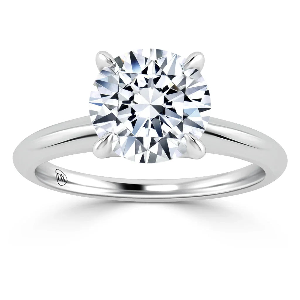 A silver solitaire ring with a large, round, brilliant-cut diamond set in a four-prong setting.