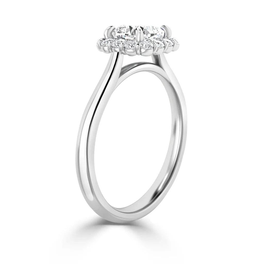 Side view of a white gold ring with a round diamond center and a halo of smaller diamonds.