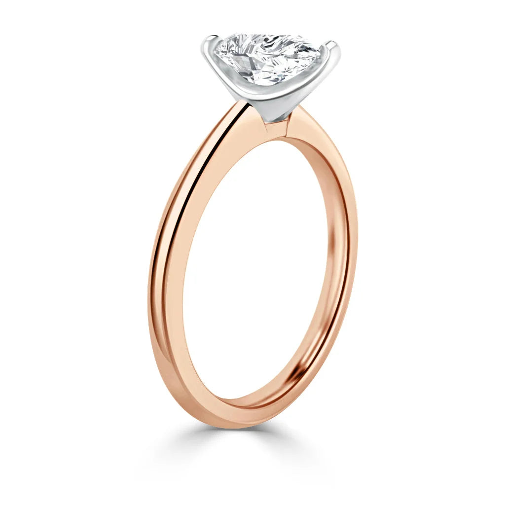 A rose gold ring with a round, white diamond set in a four-prong white gold setting.
