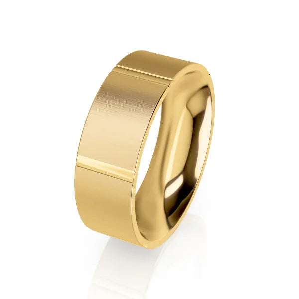 A wide, polished gold ring with a brushed finish and a single engraved line near the edge.