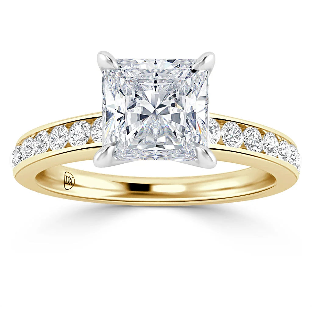 A gold ring with a large princess-cut diamond and smaller diamonds set along the band.