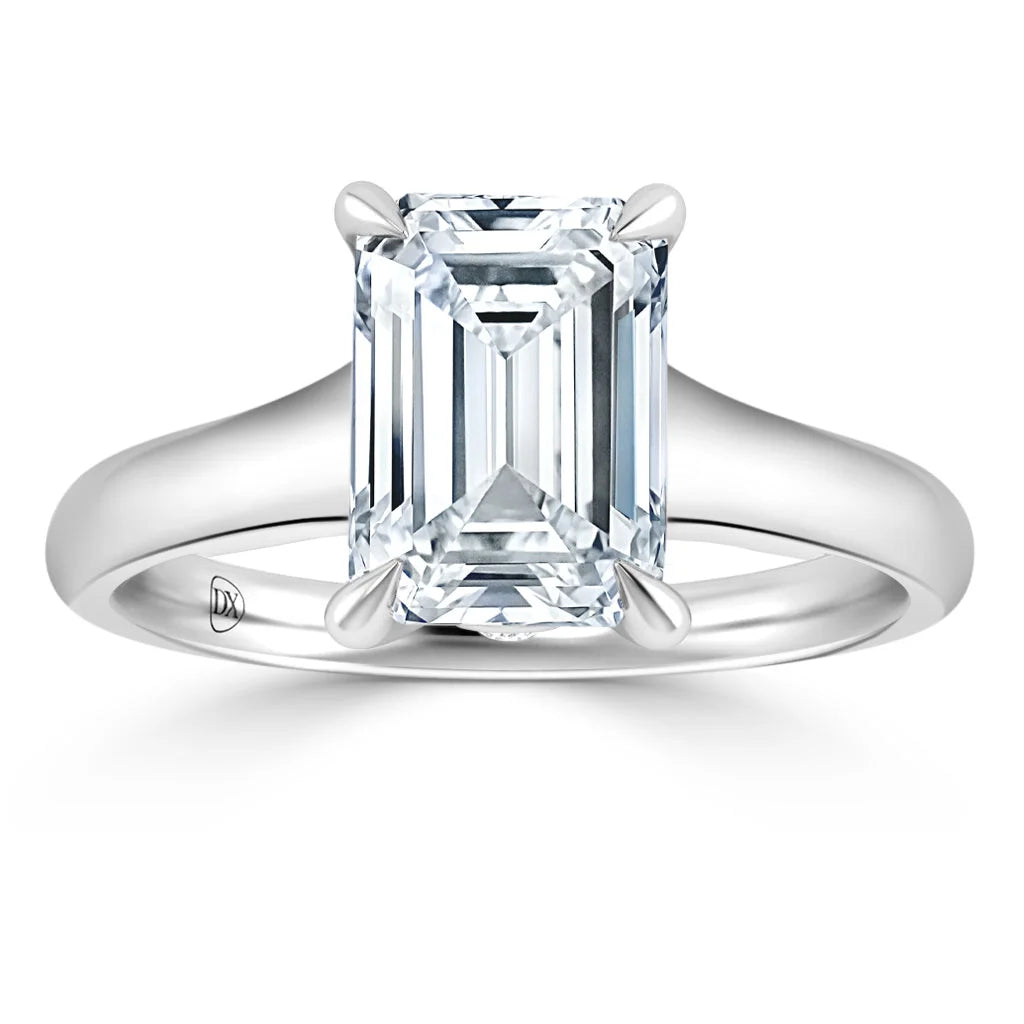 A platinum ring with an emerald-cut diamond solitaire in a four-prong setting, shown on a white background.