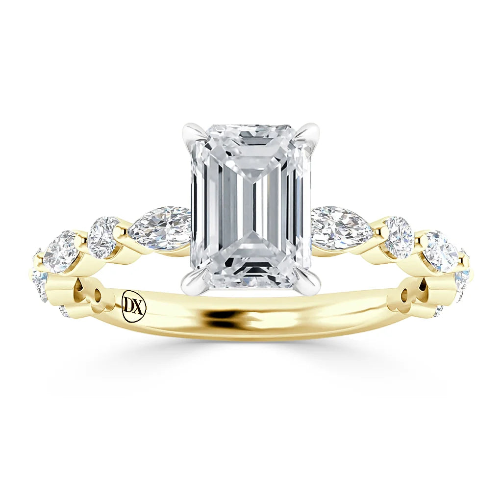 Gold ring with an emerald-cut center diamond and marquise side stones set in a twisted band design.