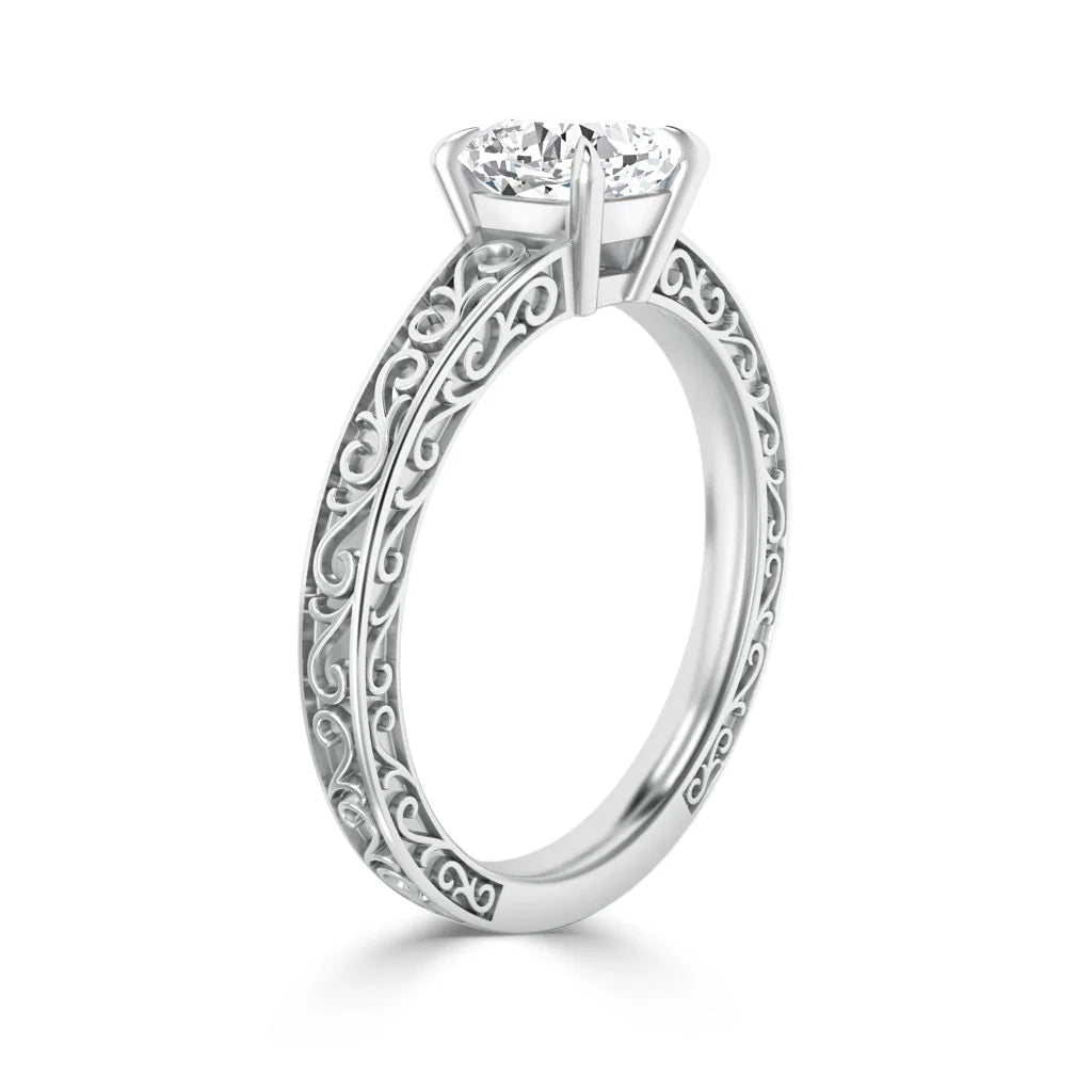 Silver ring with an ornate, scrollwork band and a single round diamond in a four-prong solitaire setting.