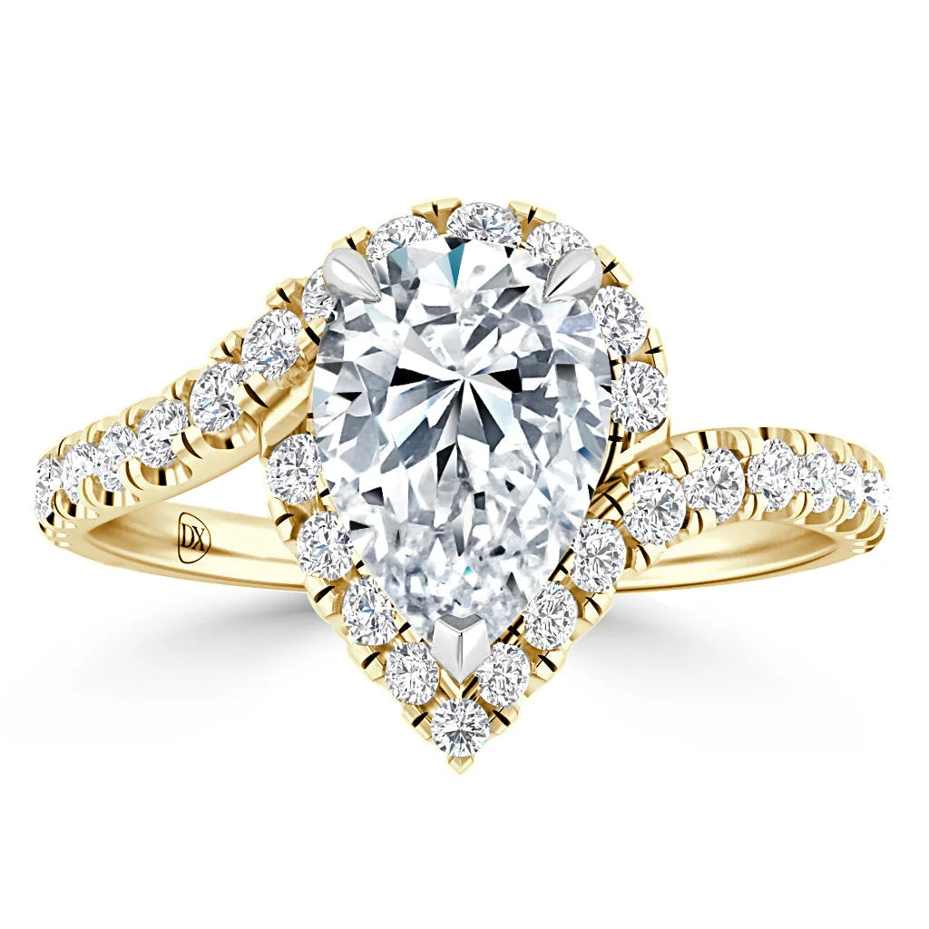 Pear-shaped diamond ring with a gold band and smaller diamonds surrounding the center stone and band.