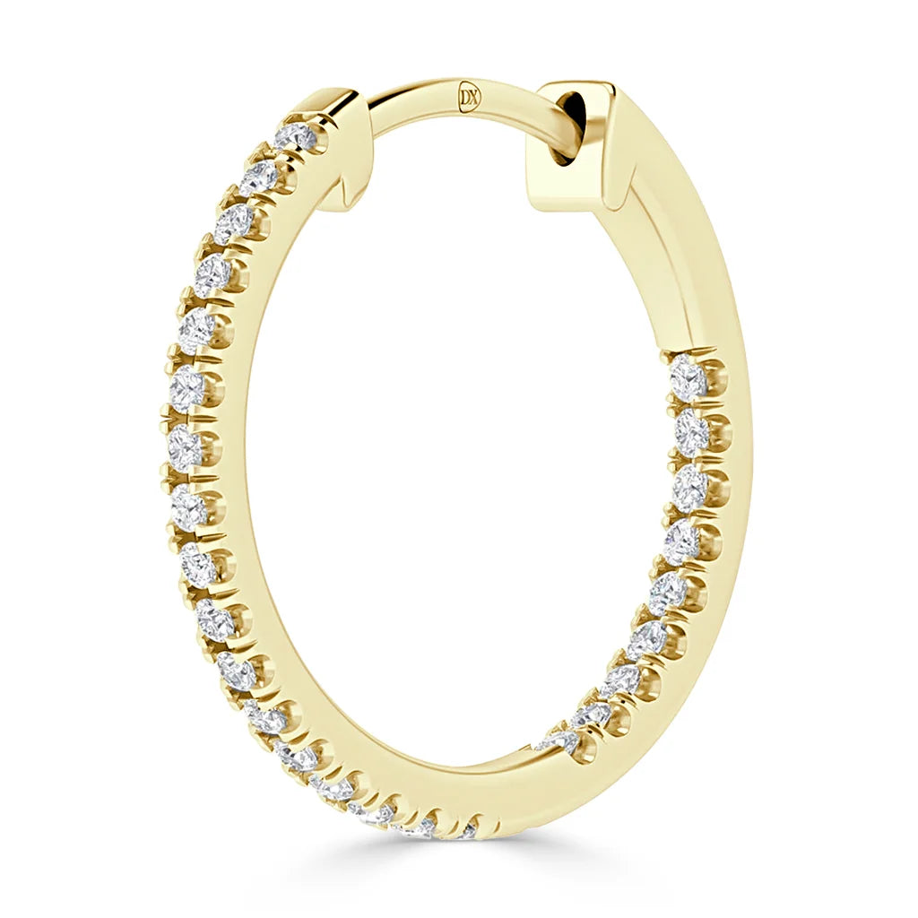 A gold hoop earring encrusted with small, sparkling diamonds around the outer edge.