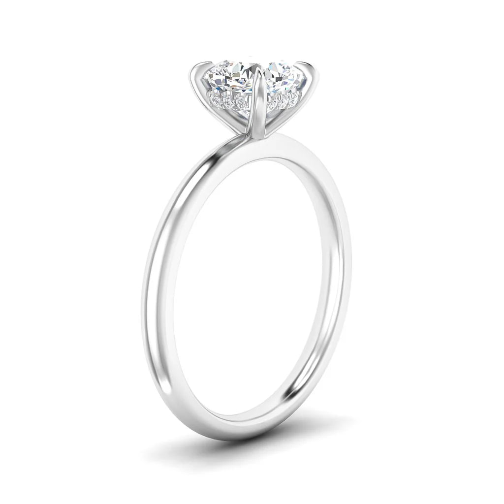 A silver solitaire engagement ring with a round, prong-set diamond against a white background.