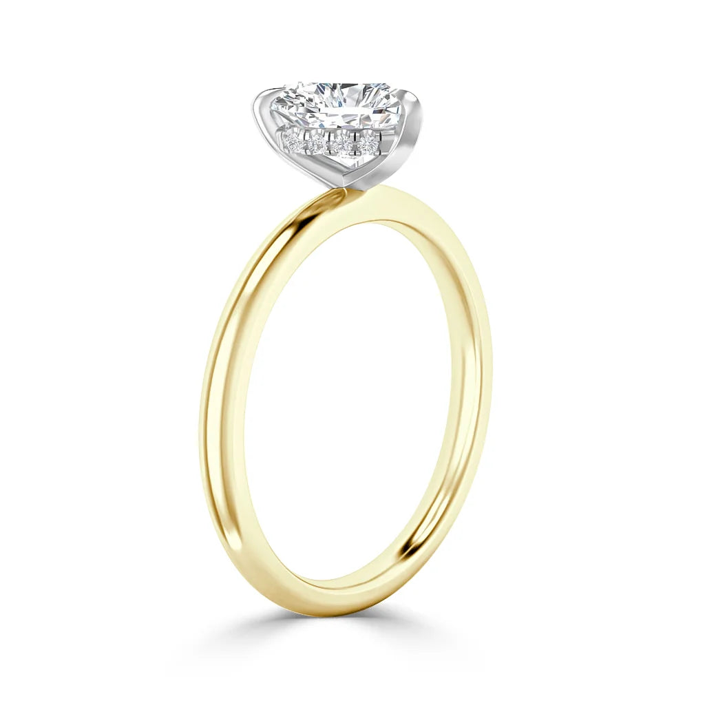 A gold ring with a round, prong-set diamond in a white gold basket setting, shown on a white background.