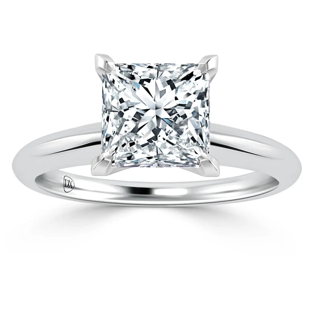 A solitaire ring with a princess-cut diamond set on a simple, polished white metal band.