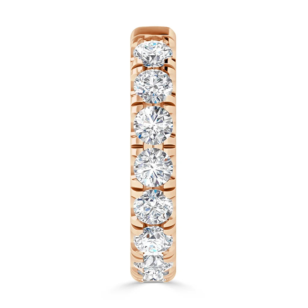 A gold ring set with seven round, sparkling diamonds in a single row, viewed from the front.