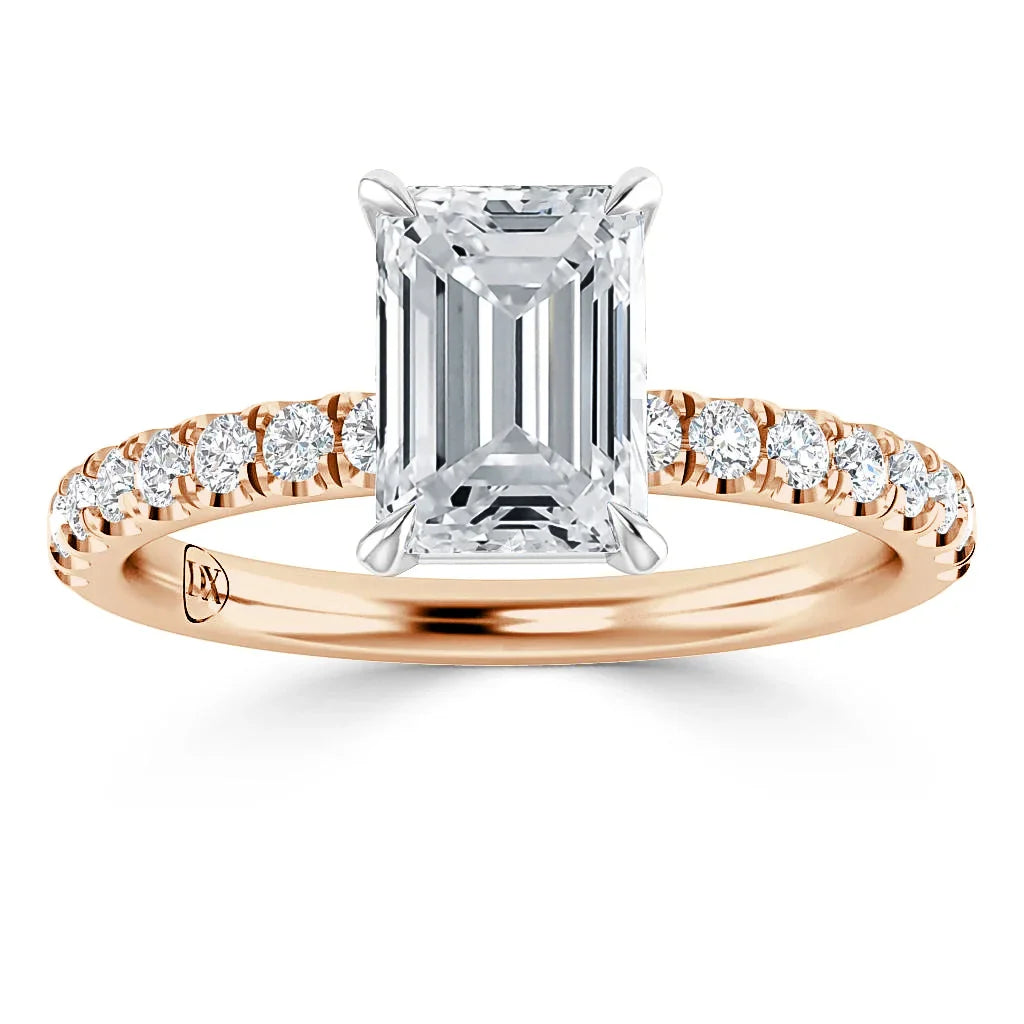 Emerald-cut diamond ring with a rose gold band, accented by small round diamonds along the band.