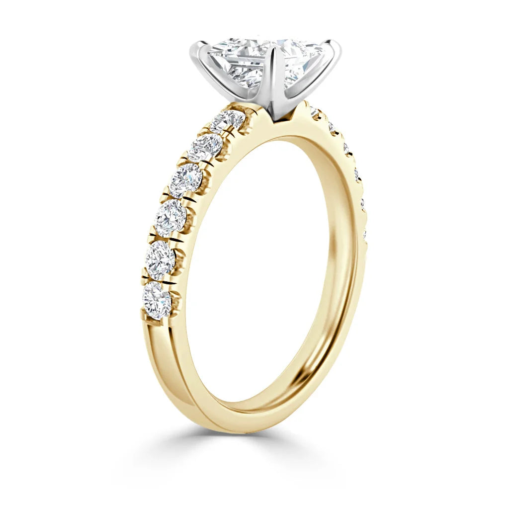A gold ring with round diamonds on the band and a large, prong-set solitaire diamond at the center.