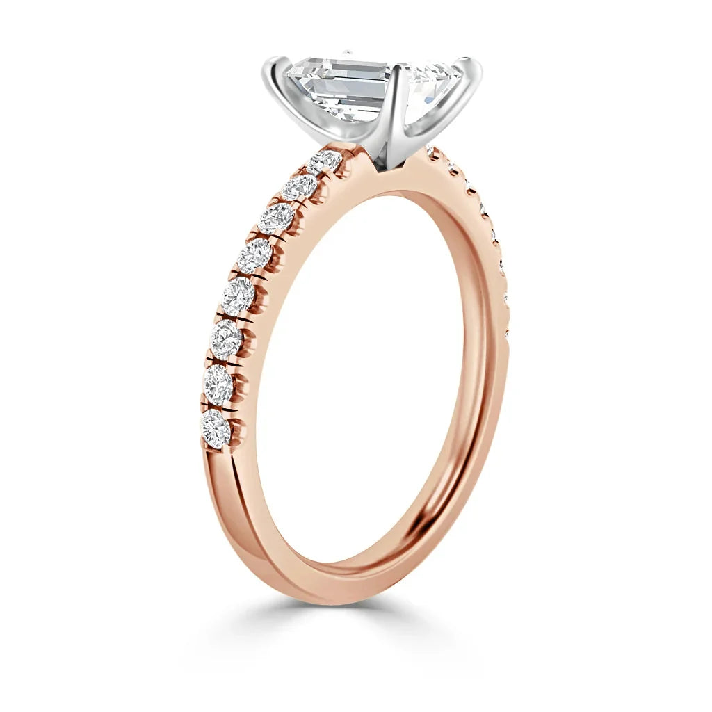 Rose gold ring with round diamonds on the band and a large oval solitaire diamond in a white gold prong setting.