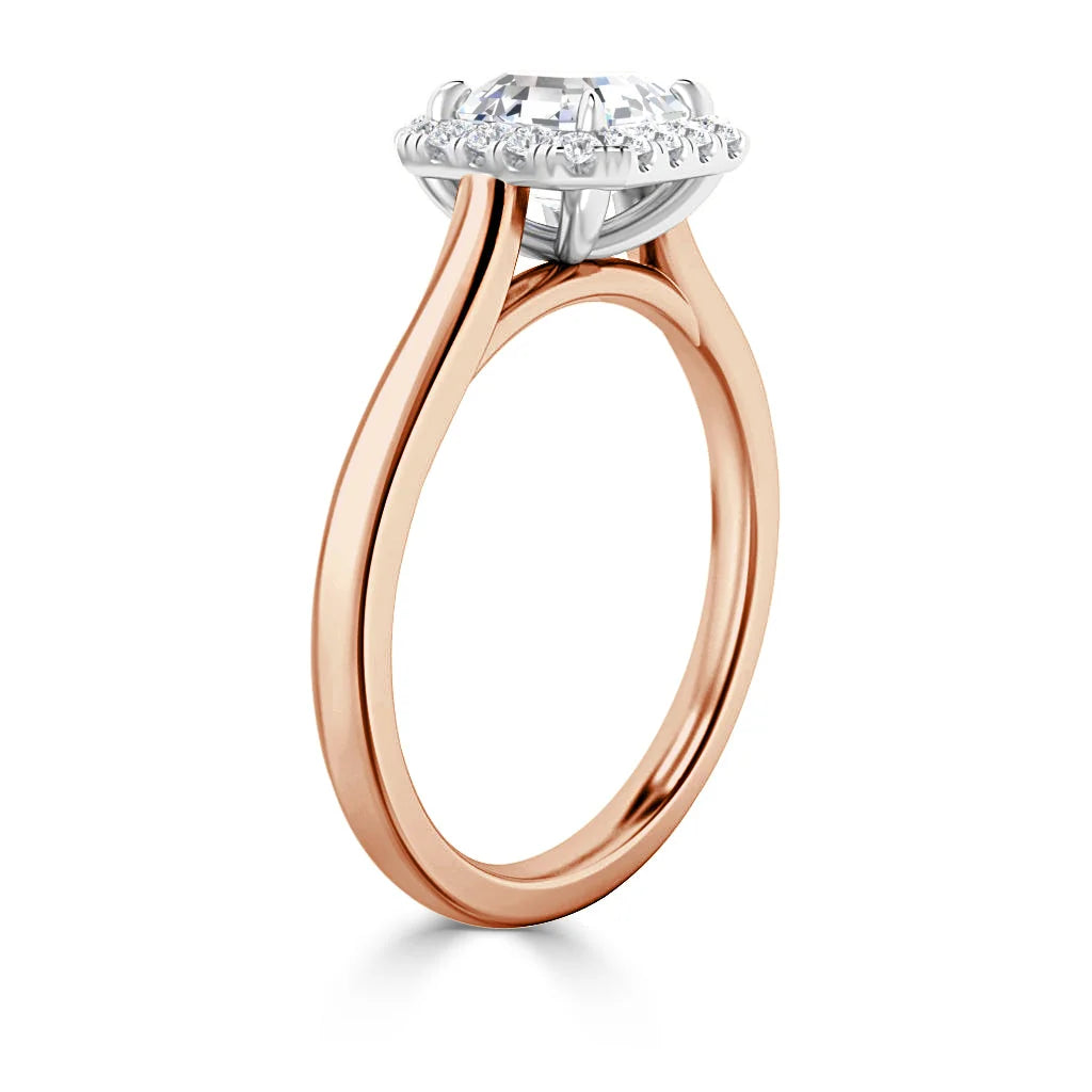 Rose gold ring with a round diamond halo setting seen from a side angle on a white background.