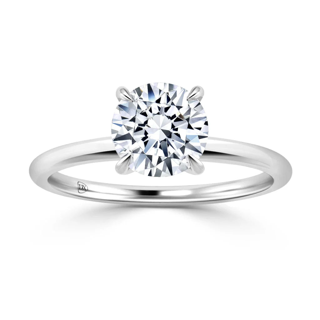 A solitaire diamond ring with a round-cut diamond set on a simple, polished white gold band.