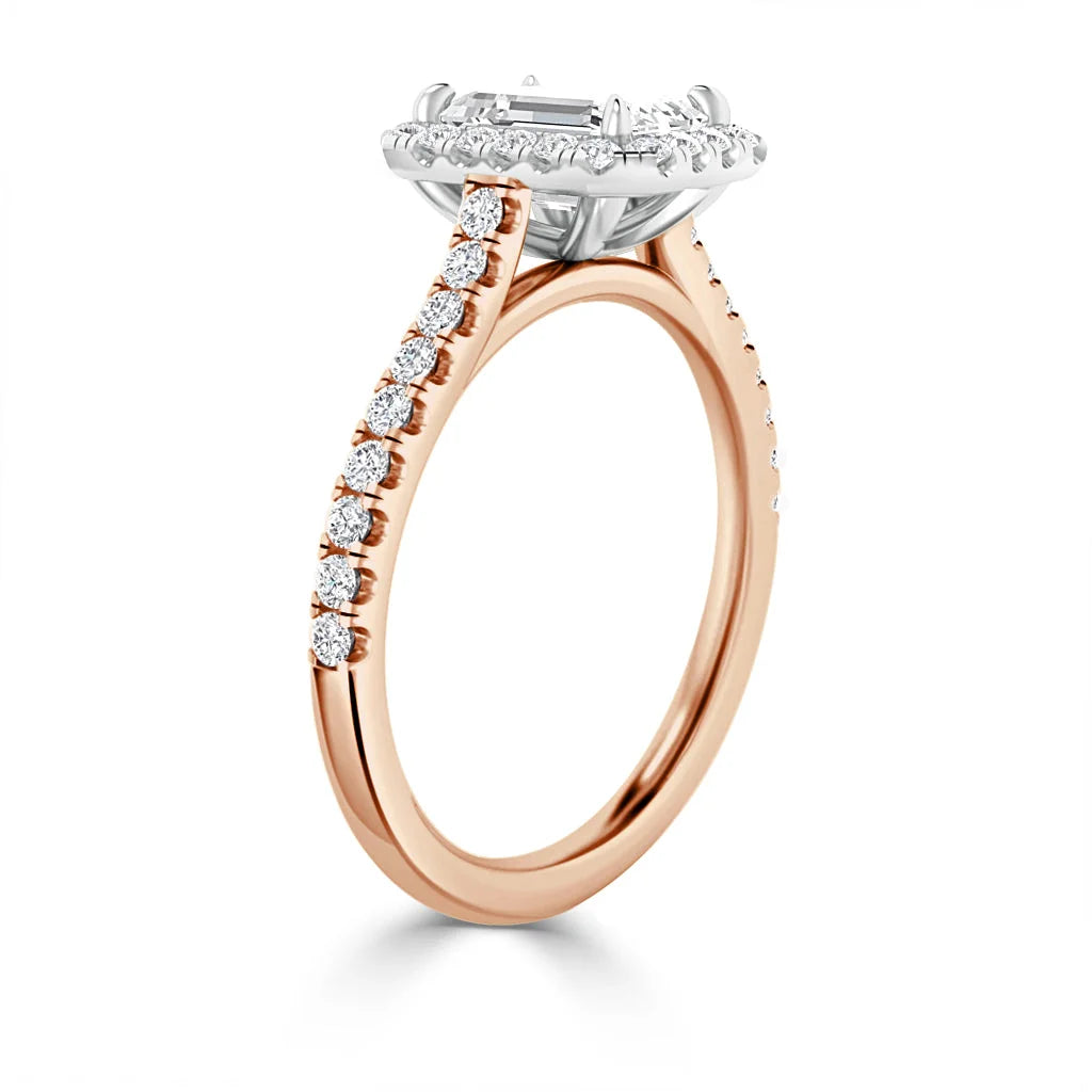 Rose gold ring with a diamond halo setting and a band accented with small round diamonds, viewed from the side.