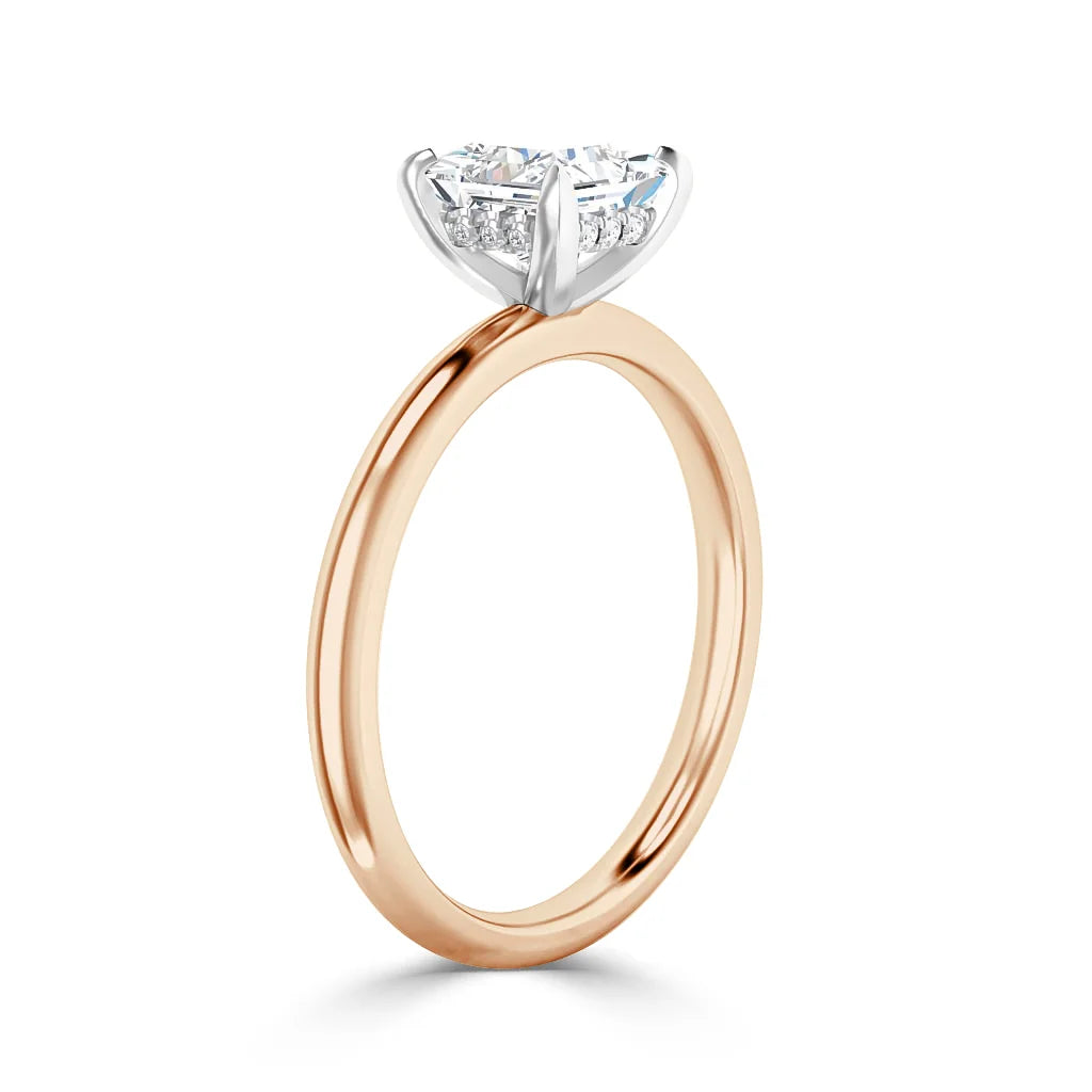 A rose gold ring with a round diamond solitaire in a white gold prong setting, shown on a white background.