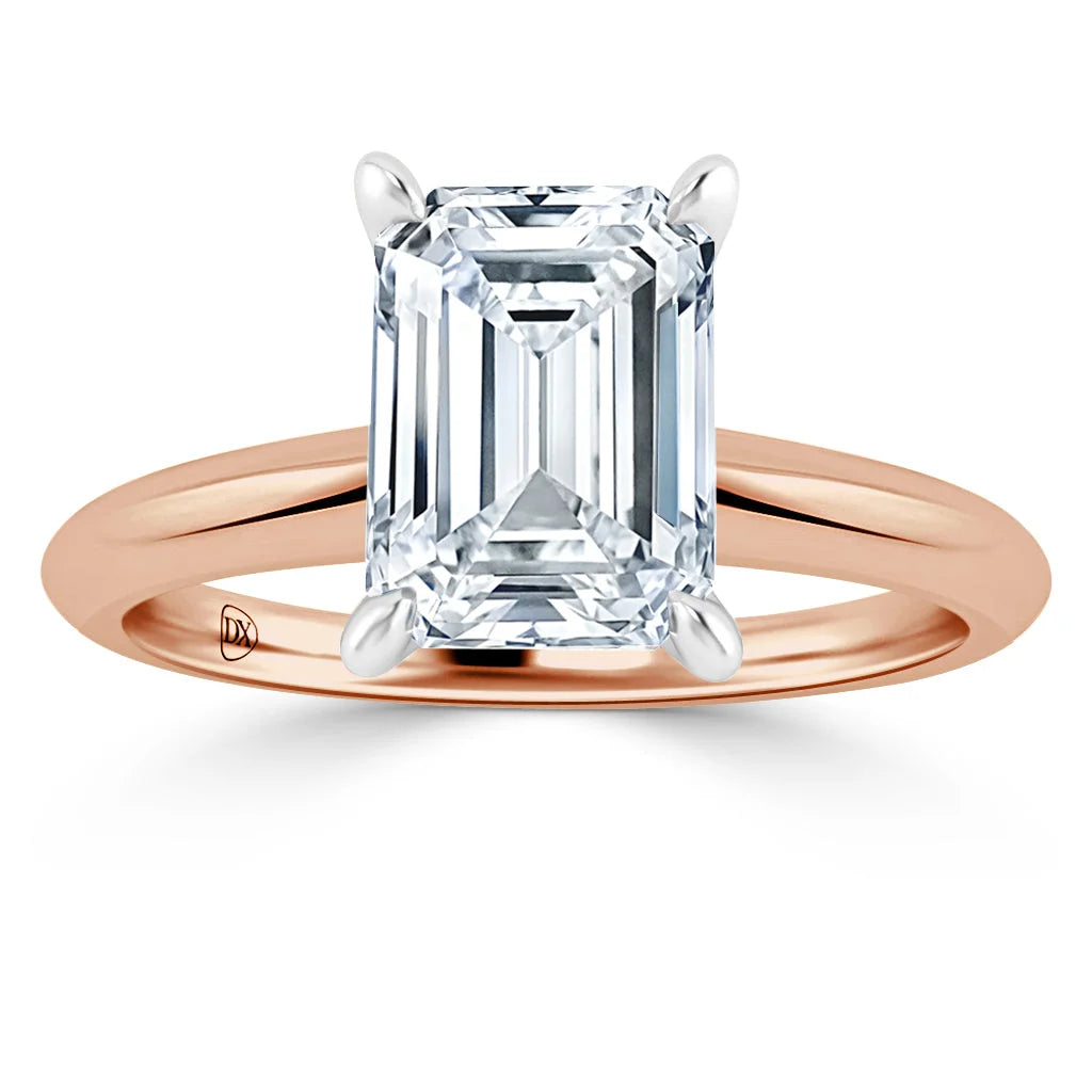 Emerald-cut diamond solitaire ring with a rose gold band and white gold prongs, viewed from the front.