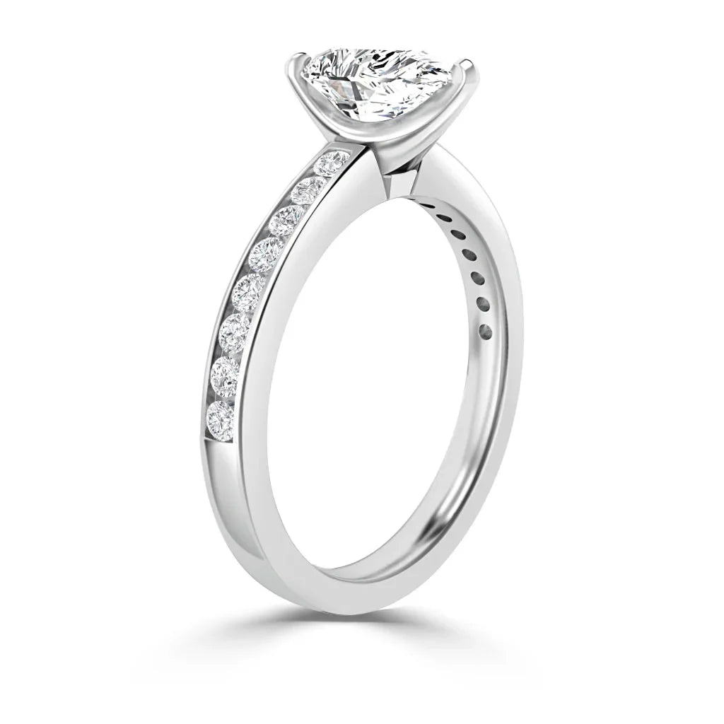 A white gold ring with a large round center diamond and smaller diamonds set along the band.