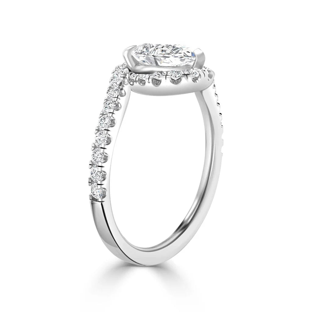 White gold ring with a cushion-cut center diamond and a band accented with small round diamonds.