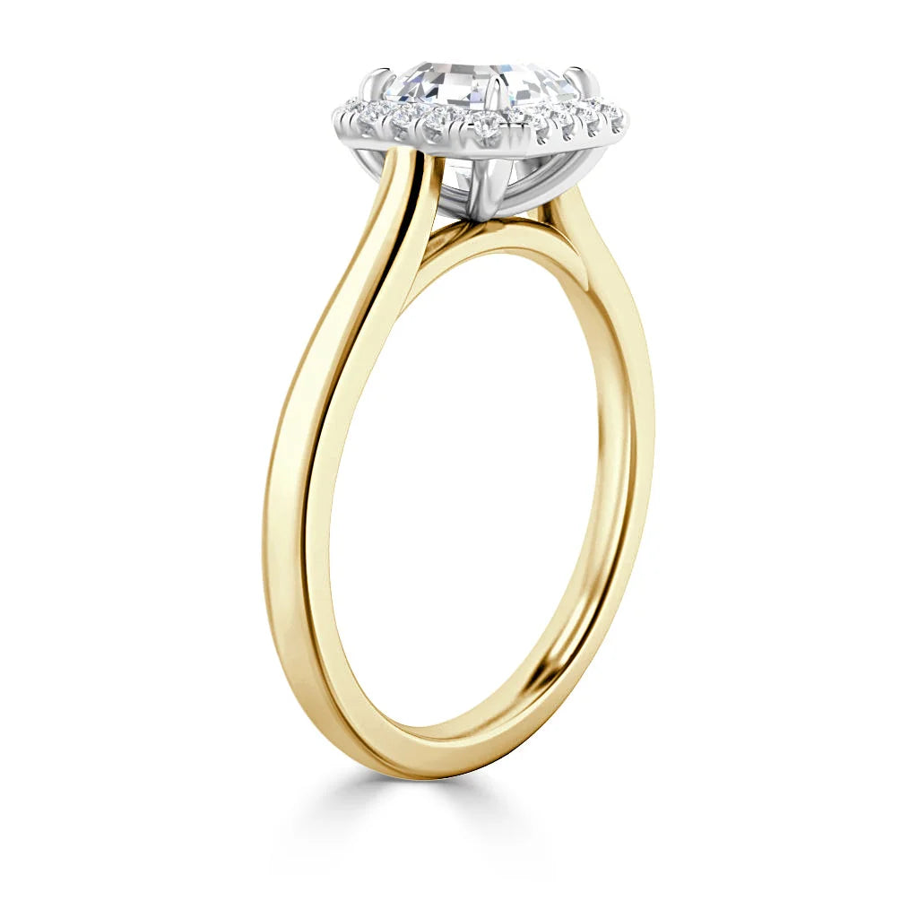 A gold ring with a round halo diamond setting and a slim, elegant band shown from a side angle.