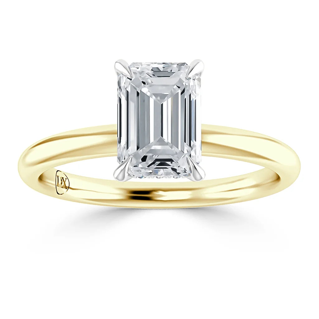 Emerald-cut diamond solitaire ring with a yellow gold band, viewed from the front against a white background.