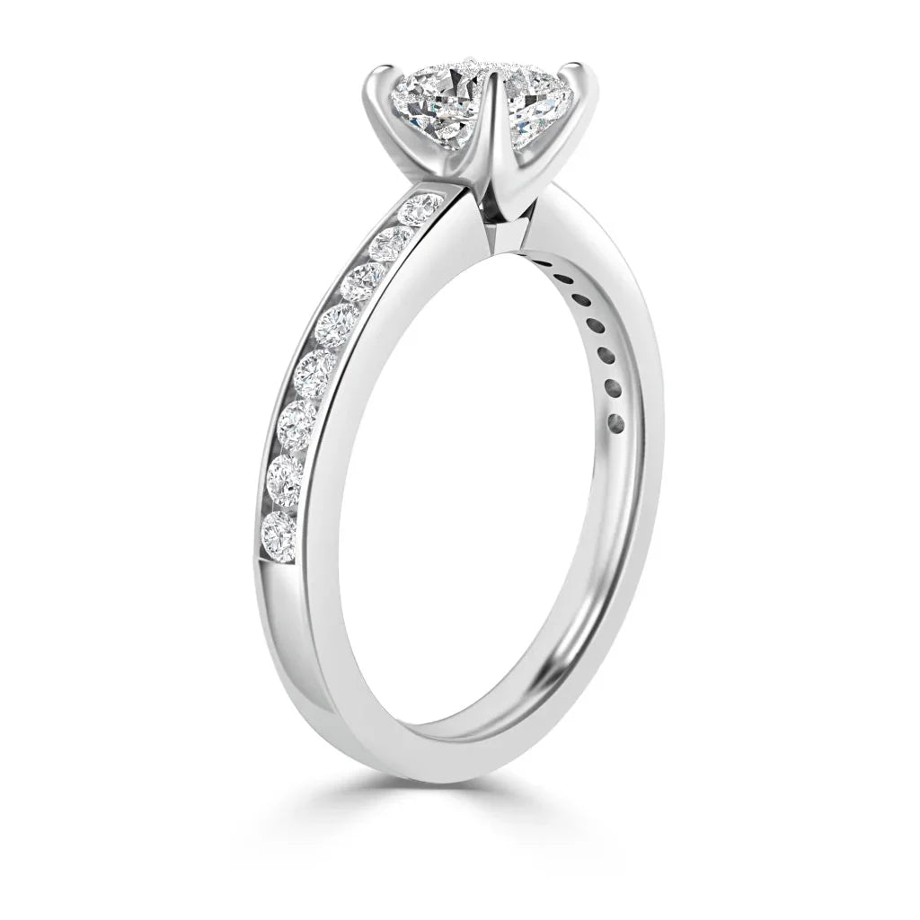 White gold ring with round diamonds set along the band and a large solitaire diamond in a prong setting.