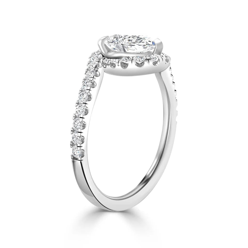 A white gold ring with a large cushion-cut diamond and smaller diamonds along the band in a side view.