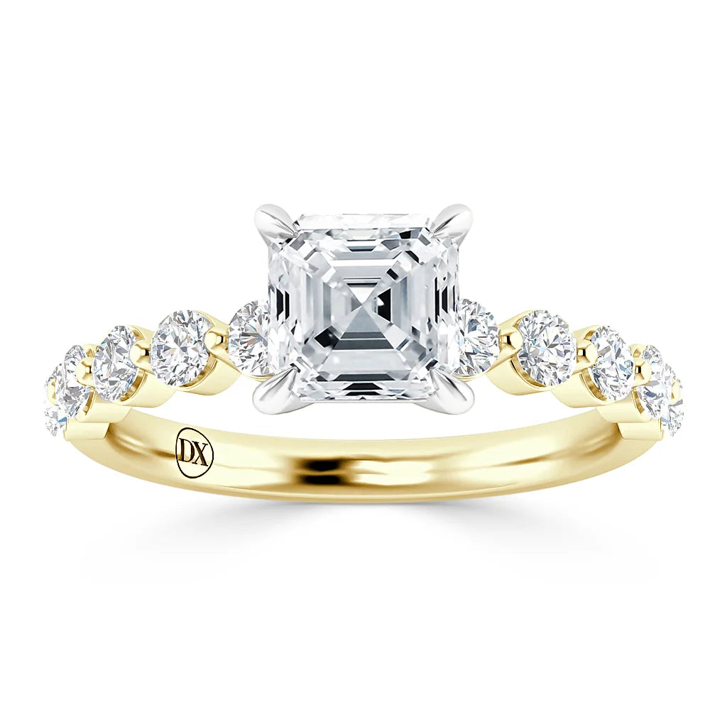 A gold ring with an Asscher-cut diamond center and round diamonds along the band, engraved with DX inside.