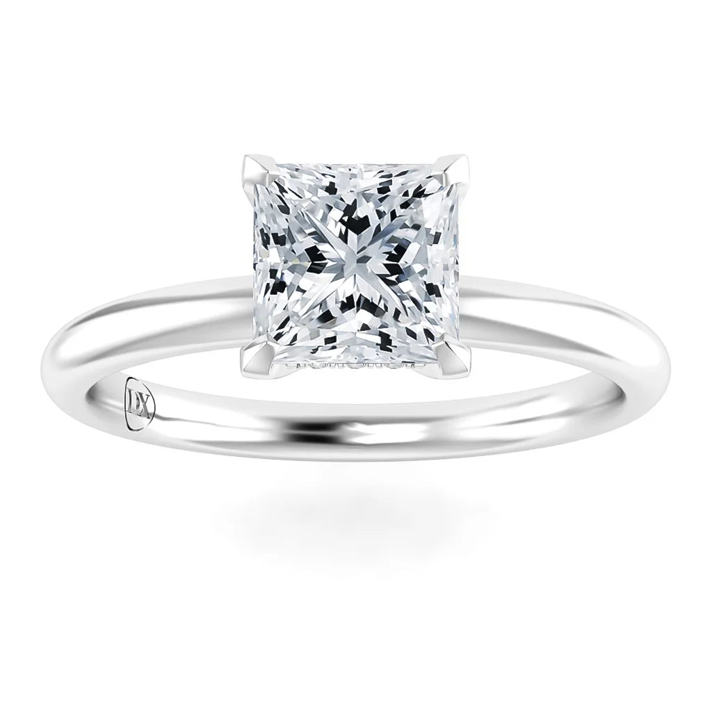 A solitaire ring with a princess-cut diamond set on a simple, polished silver band.