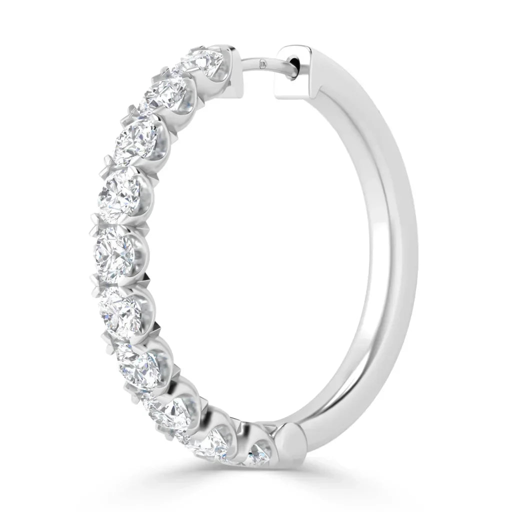 A silver hoop earring adorned with round, sparkling clear gemstones set along the front edge.